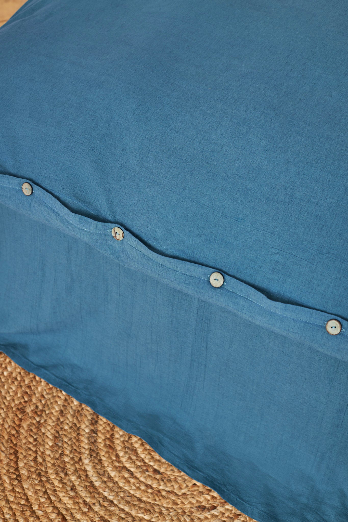 Close-up of a blue linen duvet cover with buttons 